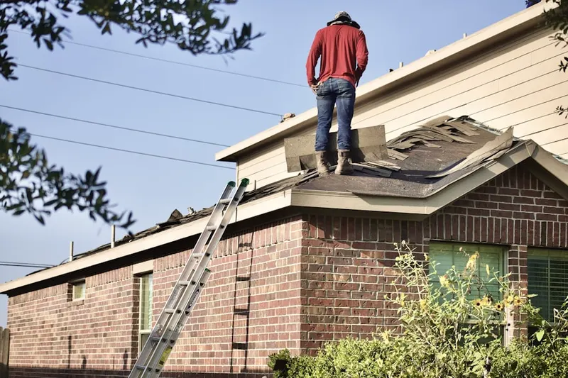 Professional roofer working on a residential roof in Gage